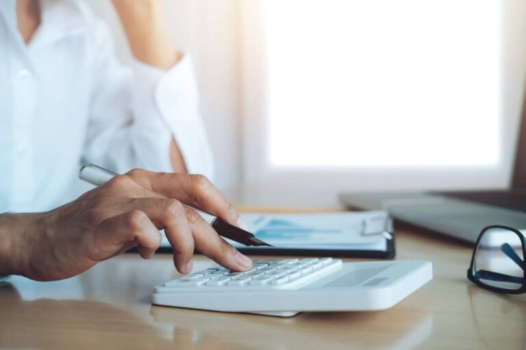 Persona calculando gastos de viajes y viáticos con Excel.